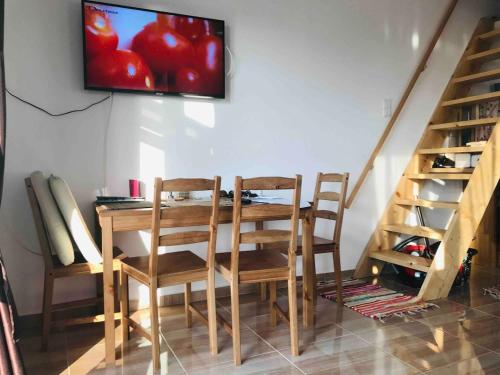 a dining room table with two chairs and a television on the wall at Samothraki Vacation Home, amazing Saos view, 2BR in Samothráki
