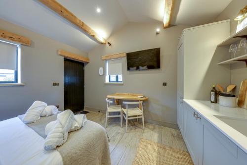a bedroom with a bed and a table in a room at Apartments for two in Brand New Luxury Rural Farmhouse Escape in Ramsbottom