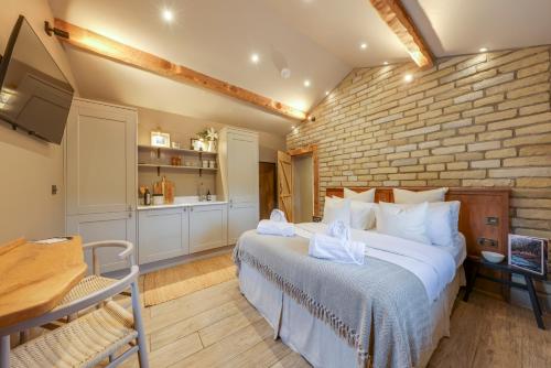 a bedroom with a large bed and a brick wall at Apartments for two in Brand New Luxury Rural Farmhouse Escape in Ramsbottom