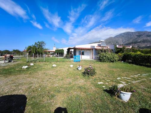 a yard with a house in the background at Samothraki Vacation Home, amazing Saos view, 2BR in Samothráki
