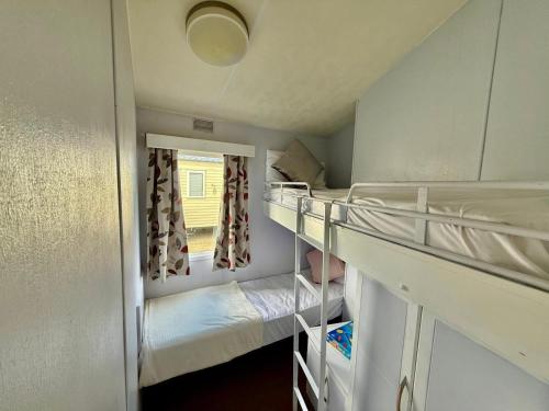a room with two bunk beds and a window at Roseanna in Kingsnorth