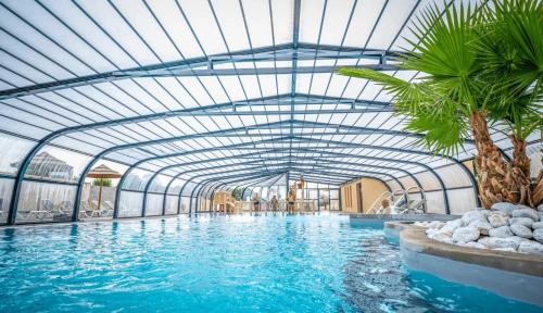 an indoor swimming pool with a glass ceiling at ZEcamping parc aquatique pet friendly club enfant in Saint-Jean-de-Monts
