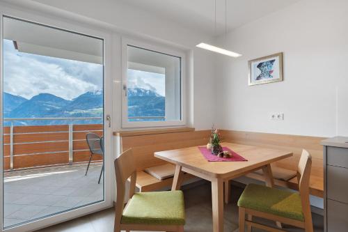 a dining room with a table and a balcony at Haus Pferscher in Barbiano