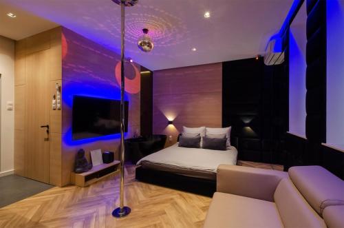 a hotel room with a bed and a couch at LupoApartments z Klimatyzacją do wyboru z Jacuzzi Pole Dance Parking Dostęp na Kod in Łódź