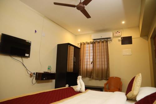 a bedroom with a bed and a ceiling fan at Kalyan Residency By Azalea in Madurai