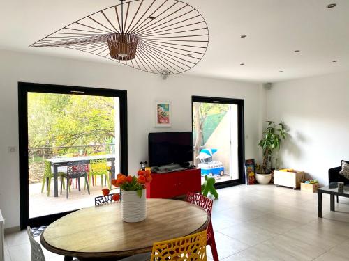 un salon avec une table et une télévision dans l'établissement charmante maison de vacances au Mourillon, à Toulon