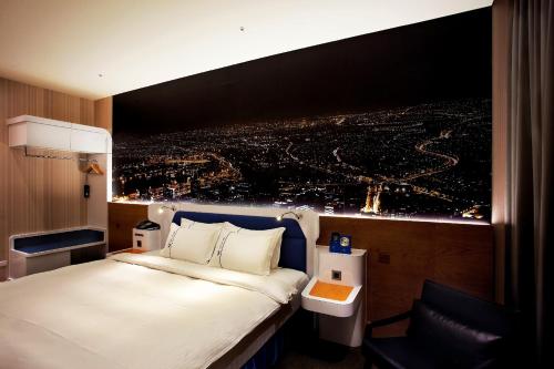 a room with a bed and a view of a city at Airline Inn Green Park Way in Taichung
