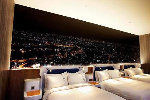 a room with two beds and a picture of a city at Airline Inn Green Park Way in Taichung
