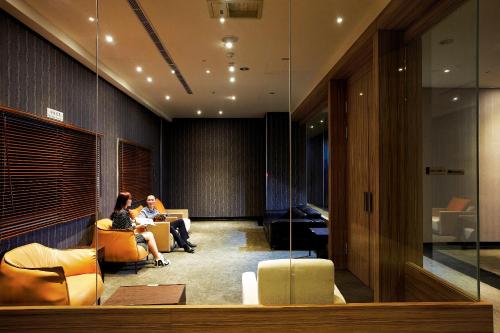 two women sitting in chairs in a lobby at Airline Inn Green Park Way in Taichung