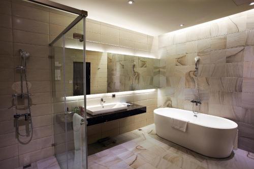 a bathroom with a tub and a sink and a shower at Airline Inn Green Park Way in Taichung