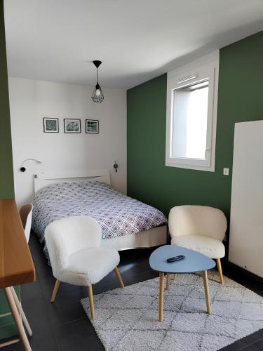 une chambre avec un lit et deux chaises et une fenêtre dans l'établissement Résidence prémium MontBlanc, à Sallanches