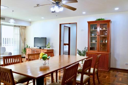 a dining room with a wooden table and chairs at Ma Peng Seng Apartment in Bangkok
