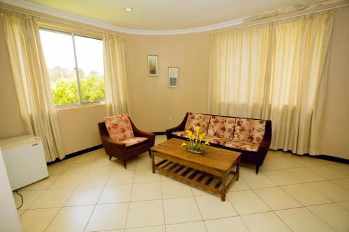 a living room with two chairs and a coffee table at Keys Hotel Mbokomu Branch in Moshi