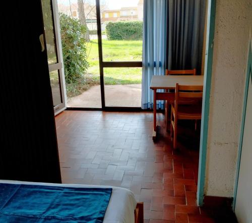 een kamer met een tafel en een tafel en een deur bij Canopéa by ULVF in Sainte-Marie-la-Mer