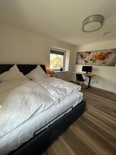 a bedroom with a white bed and a desk at Mohla-Suite in Köditz