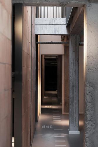 a hallway in a building with concrete pillars and lights at Roberta's Society Aarhus in Aarhus
