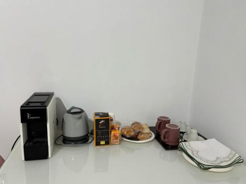 a counter top with a coffee maker and coffee cups at CG HOME City Centre in Cosenza