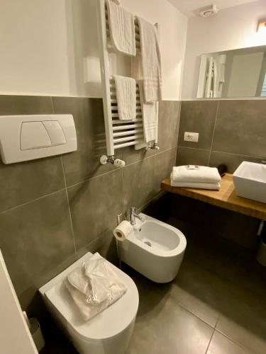 a bathroom with a white toilet and a sink at Casale Valle Cardinale in Valmontone
