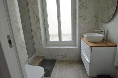 une salle de bain avec un lavabo et une fenêtre dans l'établissement Studio entre plage et centre Cannes, à Cannes