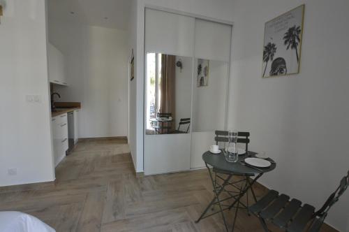 une pièce avec une table et des chaises et une cuisine dans l'établissement Studio entre plage et centre Cannes, à Cannes