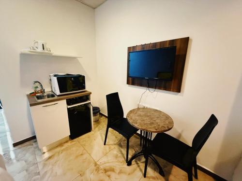 a living room with a table and chairs and a television at Slimiza Suites in Sliema