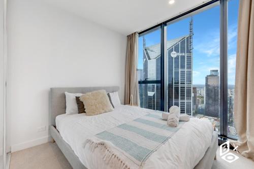 una camera da letto con un letto e una grande finestra di REST Melbourne Central Apartment a Melbourne