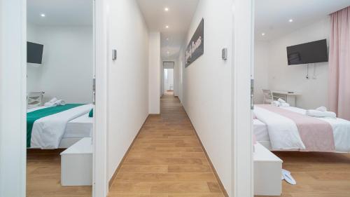 a corridor in a hotel room with two beds at Lovely Rooms by Rentbeat in Civitavecchia