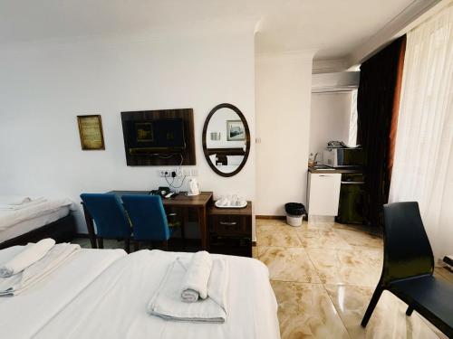 a bedroom with two beds and a desk and a mirror at Slimiza Suites in Sliema