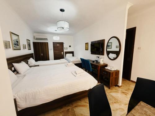a bedroom with a bed and a desk and a mirror at Slimiza Suites in Sliema