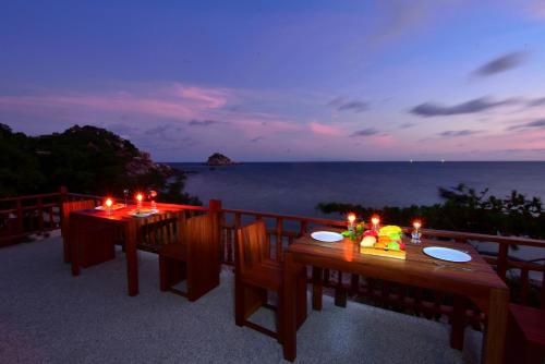 two tables on a balcony with a view of the ocean at Sai Daeng Resort in Koh Tao