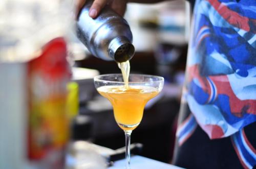 a person is pouring a drink into a glass at Sai Daeng Resort in Koh Tao