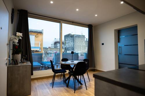 a kitchen with a table and chairs and a large window at casa con veranda e idromassaggio in Barletta
