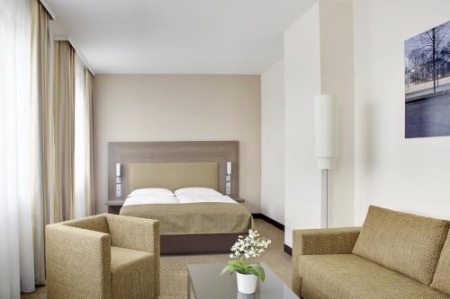 a hotel room with a bed and a chair at IntercityHotel Leipzig in Leipzig