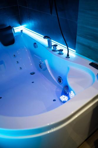 a white bath tub with a blue light on it at casa con veranda e idromassaggio in Barletta
