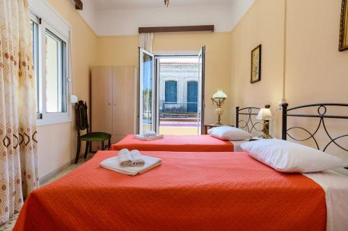 two beds in a room with red sheets and towels at Chania Vintage Escape - sea view Gem by old port in Chania Town