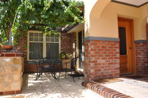 a patio with chairs and a table next to a building at Apartments on Fiedler in Tanunda