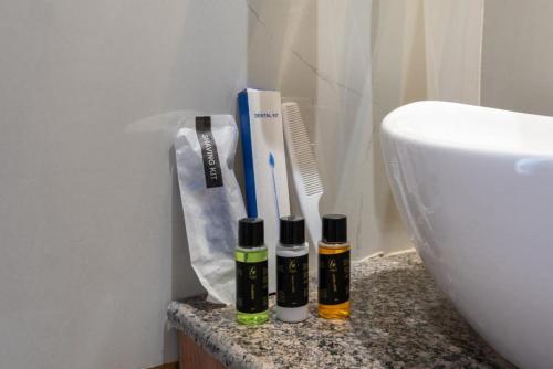 a bathroom counter with two bottles of essential oils and a sink at Qotel Signature - Golf Course Road in Gurgaon