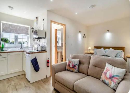 a living room with a couch and a kitchen at Great Sampford B&B Sorrells farm in Hempstead
