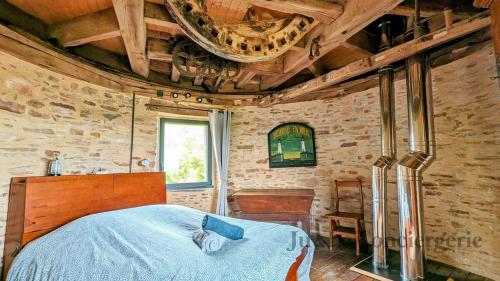 une chambre avec un lit et un plafond en bois dans l'établissement So Romantic - Le Moulin de Camargois, à Avessac