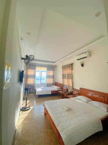 a bedroom with two beds and a living room at Nhà nghỉ Majestic Cô Tô in Quang Ninh