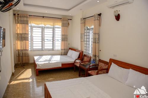 a bedroom with a bed and a couch and a table at Nhà nghỉ Majestic Cô Tô in Quang Ninh