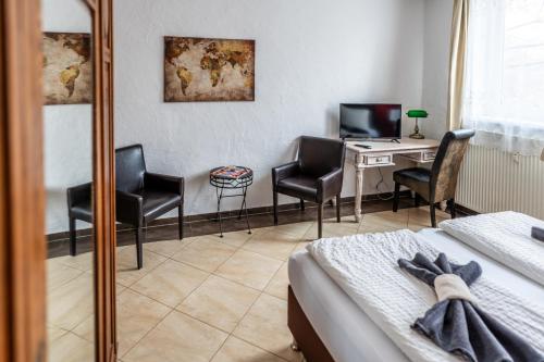 a hotel room with a desk and chairs and a bed at Villa Backstein OBO19 in Schwerin