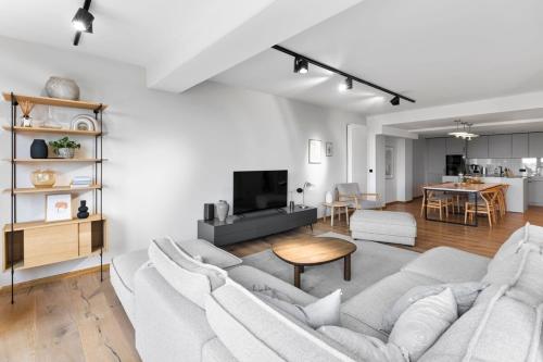 a white living room with a couch and a table at Luxus Meerblick Strand & Sauna & Garten & Heimkino in Glowe