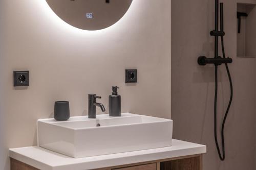 a bathroom with a sink with a light above it at Luxus Meerblick Strand & Sauna & Garten & Heimkino in Glowe