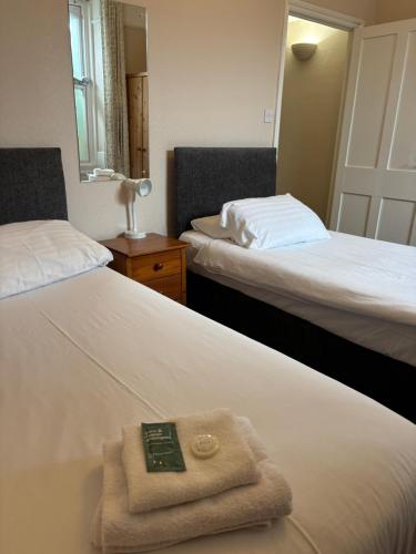 a hotel room with two beds with a remote control on the bed at Carnock in Tenby