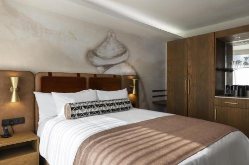 a bedroom with a large bed and a wooden cabinet at Mpilo Boutique Hotel in Maseru
