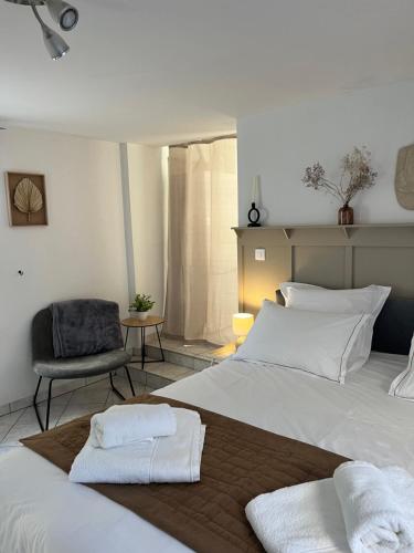 a bedroom with two white beds and a chair at Appartement T1 Côté jardin à Thionville in Thionville