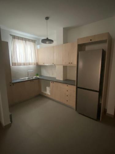 an empty kitchen with a refrigerator and a sink at 11studio in Nafplio