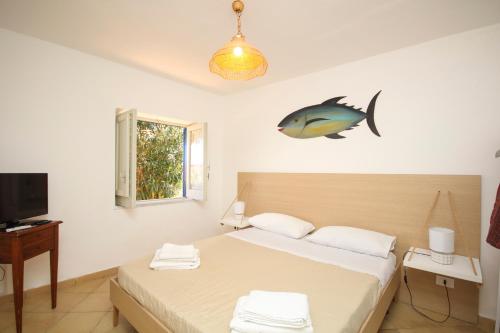 a bedroom with two beds and a fish on the wall at Dimore di mare - Beachfront Apartments in Santa Flavia