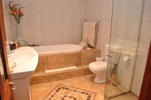 a bathroom with a tub and a toilet and a sink at Apartments on Fiedler in Tanunda